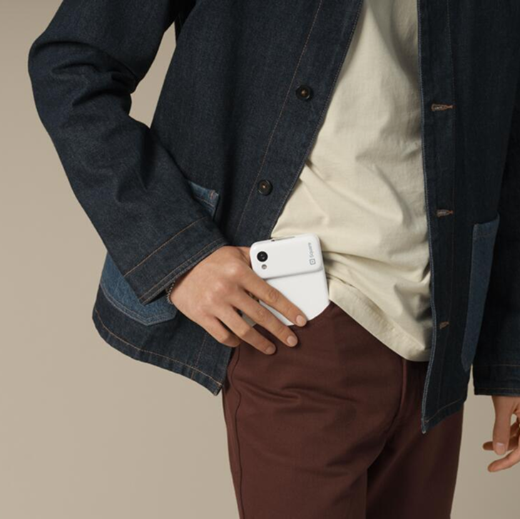 Square handheld device sliding into pocket